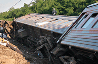 Сбившиеся в кучу вагоны поезда лежат рядом с рельсами, колесами вверх