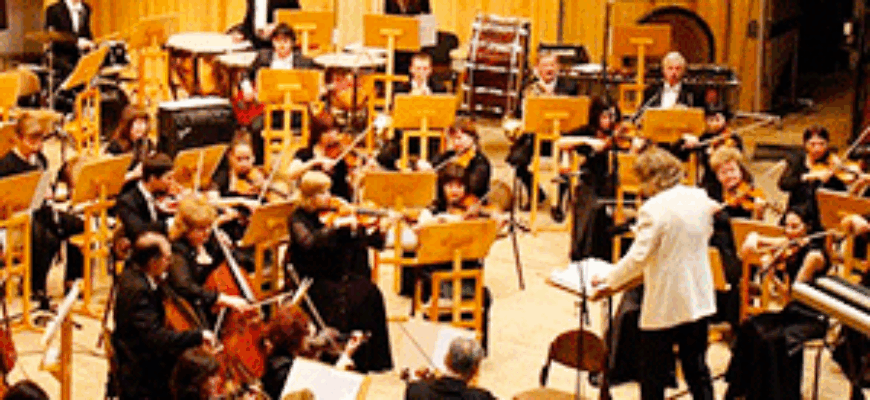 Звук настройки оркестра перед концертом — музыканты в зале