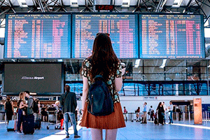 Звуки аэропорта скачать — девушка стоит перед табло с расписанием самолетов